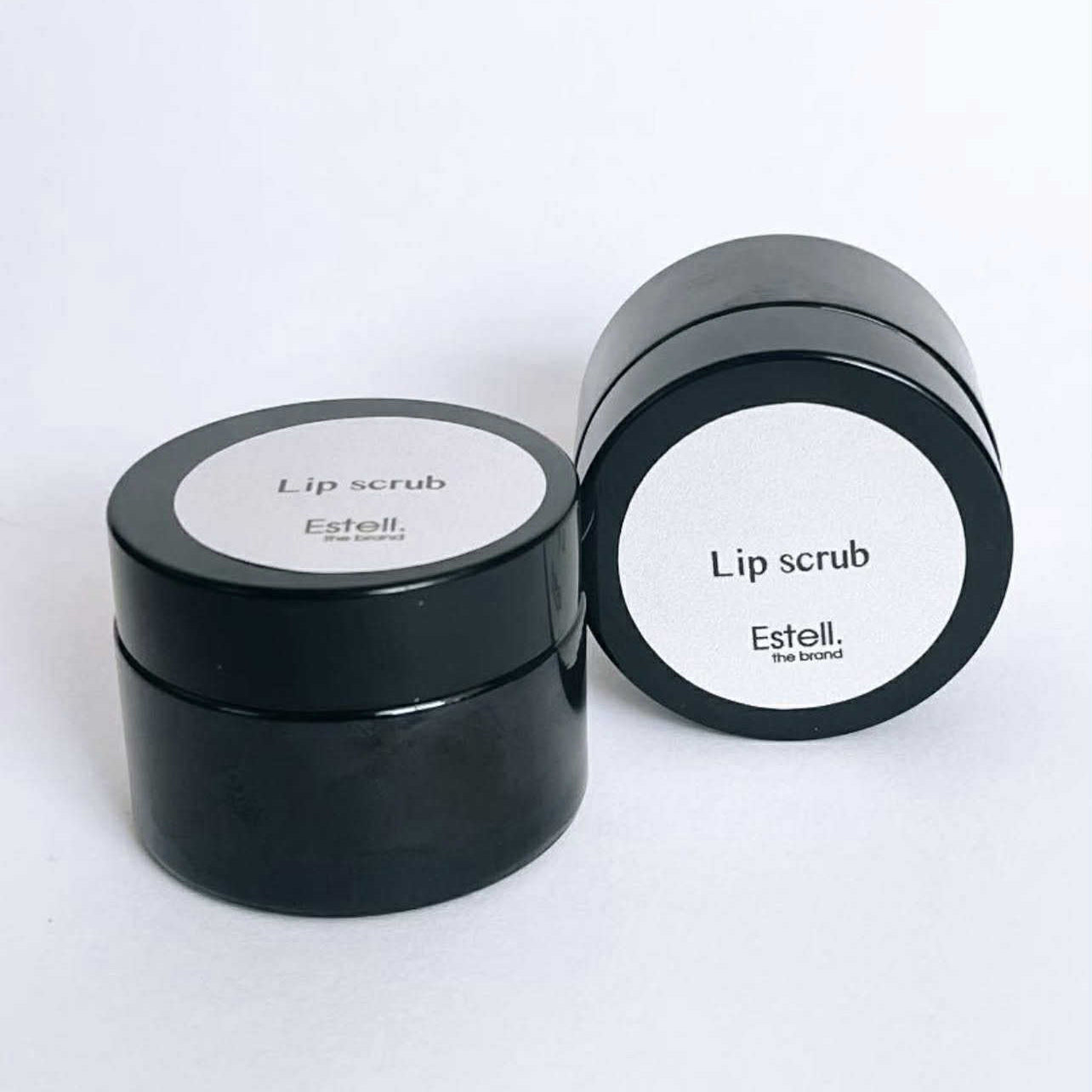 Two black lip scrub containers with white labels on a white background